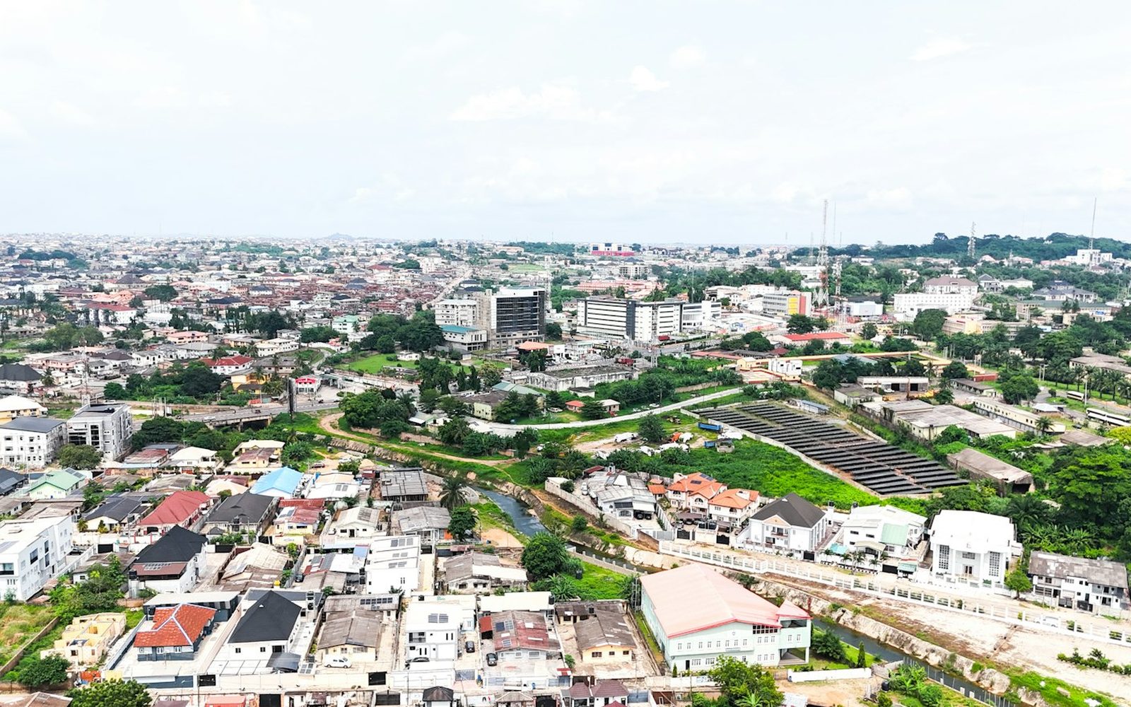 An aerial view across rooftops and green streets of a suburban neighbourhood